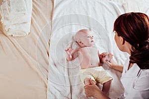 The little boy baby mother doing massage hands and legs