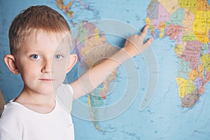Little boy on the background of a world map