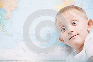 Little boy on the background of a world map