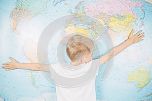 Little boy on the background of a world map