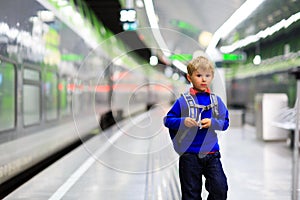 Little boy with backpack travel by train