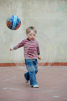 LIttle boy in the backyard with a ball