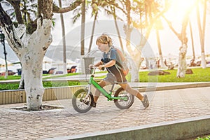 Little boy on a balance bike. Caught in motion, on a driveway. P