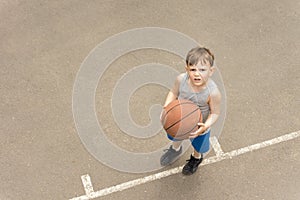 Little boy with a basketball looking puzzled