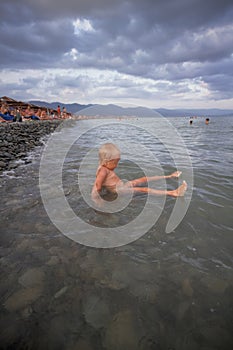 Little boy bathes in the sea