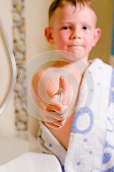 Little boy in the bathroom giving a thumbs up