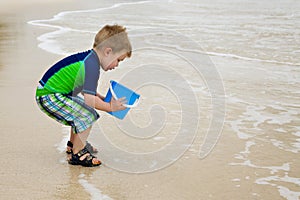 Little Boy on the Beach with a Blue Bucket