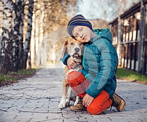 Little boy with beagle on the autumn street