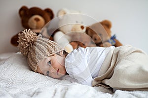 Little boy in bed with teddy bears around