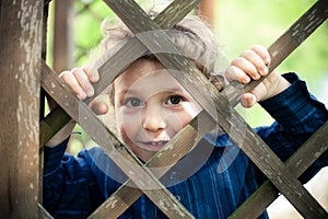 Little boy behind the fence