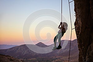 Little boy being lowered down while top rope climbing