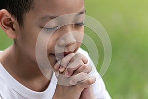 Little boy with Bible praying and close your eyes in praying. Prayer to pray. Children pray with folded hands
