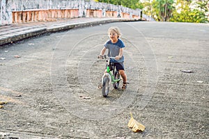 Little boy on a bicycle. Caught in motion, on a driveway motion blurred. Preschool child`s first day on the bike. The