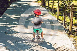 Little boy on a bicycle. Caught in motion, on a driveway motion blurred. Preschool child`s first day on the bike. The joy of move