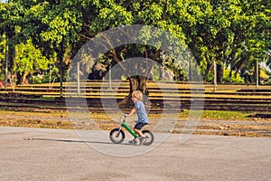 Little boy on a bicycle. Caught in motion, on a driveway. Presch