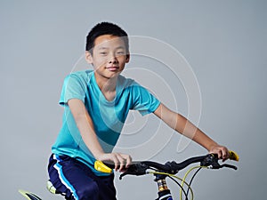 Little boy with bicycle on grey background