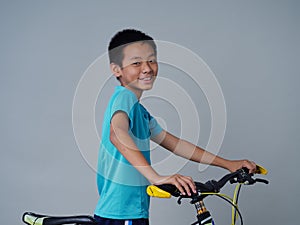 Little boy with bicycle on grey background