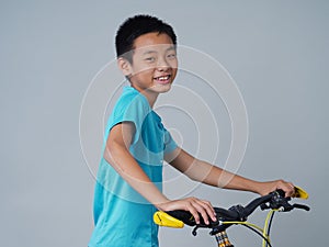 Little boy with bicycle on grey background