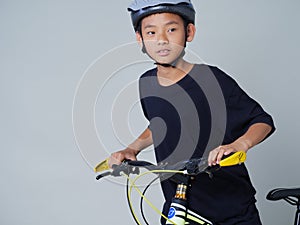 Little boy with bicycle on light background