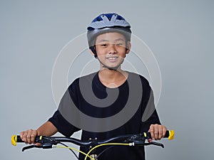 Little boy with bicycle on light background