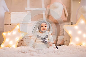 Little boy with birthmark in Christmas rabbit costume posing at white Christmas studio