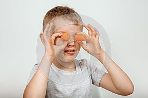 Little boy biting the carrot, isolated on white