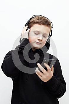 Little boy in black hoodie and headphones. listening music