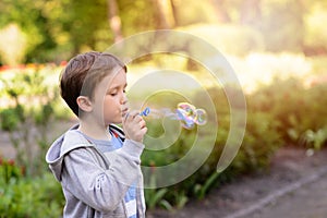 Little boy blowing soap bubbles in the park