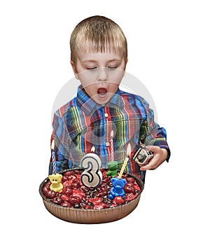 Little boy blows out the cake candles for his birthday. Sweet cake with food candle. Isolated