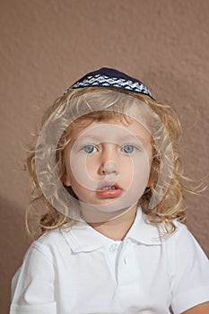 The little boy with blue eyes in Jewish knitted skullcap