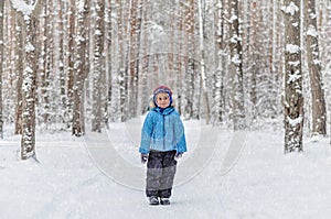 Little boy in a blue outwear having fun in the forest