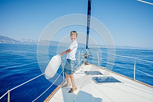 Little boy on board of sailing yacht on summer cruise. photo