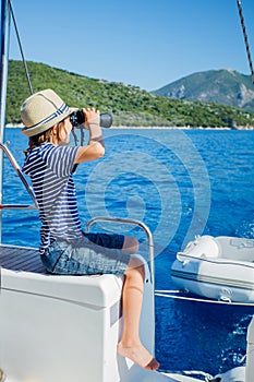 Little boy on board of sailing yacht on summer cruise. Travel adventure, yachting with child on family vacation.