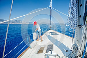 Little boy on board of sailing yacht on summer cruise. Travel adventure, yachting with child on family vacation.