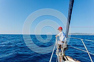 Little boy on board of sailing yacht on summer cruise. Travel adventure, yachting with child on family vacation.