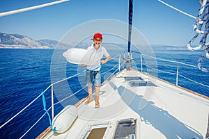 Little boy on board of sailing yacht on summer cruise. Travel adventure, yachting with child on family vacation.