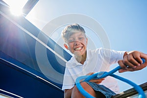 Little boy on board of sailing yacht on summer cruise. Travel adventure, yachting with child on family vacation.