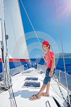 Little boy on board of sailing yacht on summer cruise. Travel adventure, yachting with child on family vacation.