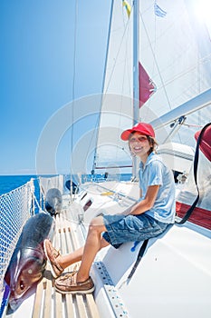 Little boy on board of sailing yacht on summer cruise. Travel adventure, yachting with child on family vacation.