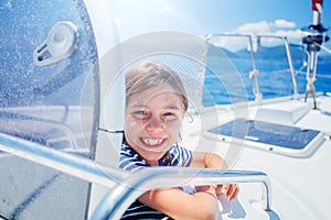 Little boy on board of sailing yacht on summer cruise. Travel adventure, yachting with child on family vacation.