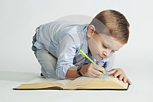 Little boy with book on the floor. funny child writer