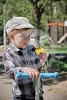 Little boy with a bouquet of yellow dandelions.