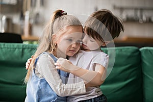 Little boy brother consoling and supporting upset girl embracing