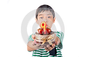 Little boy browing candle on the cake for his birthday