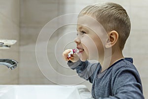 A little boy brushes his teeth in the bathroom. Hygiene and health. Close-up