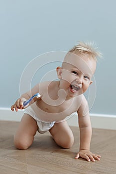 little boy brushes his teeth with a toothbrush and laughs