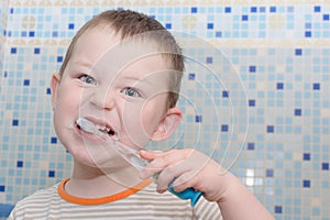 Little boy brushes teeth in the bathroom. The concept is to teach children to be independent, to accustom them to