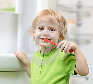 Little boy brushing his teeth in bathroom