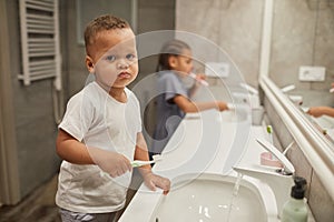 Little Boy Brushing Teeth in Bathroom