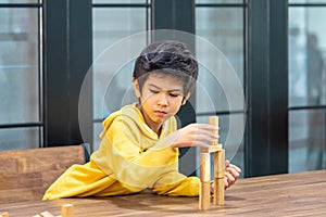 Little Boy building wooden toy block tower